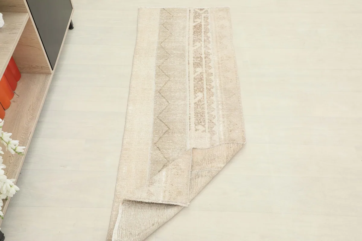The runner rug partially folded to show its flexibility and thickness.