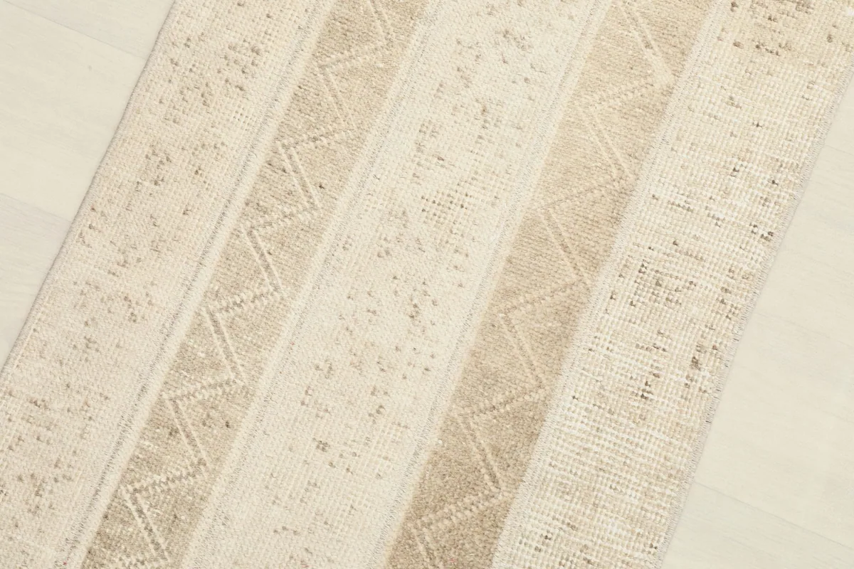Detailed view of the wool pile and the subtle variations in the beige and tan stripes.