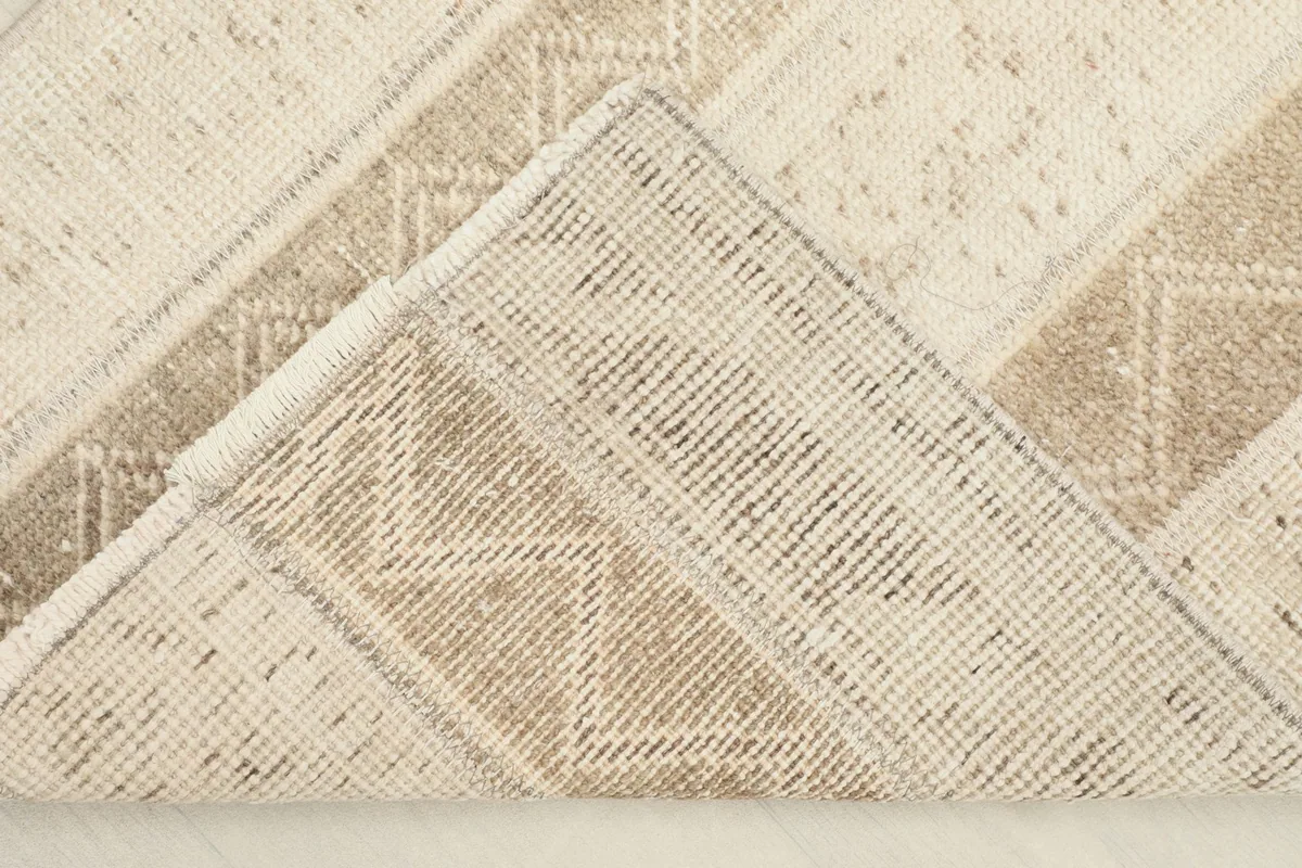 Corner lifted to reveal the hand-knotted cotton foundation on the back of the rug.