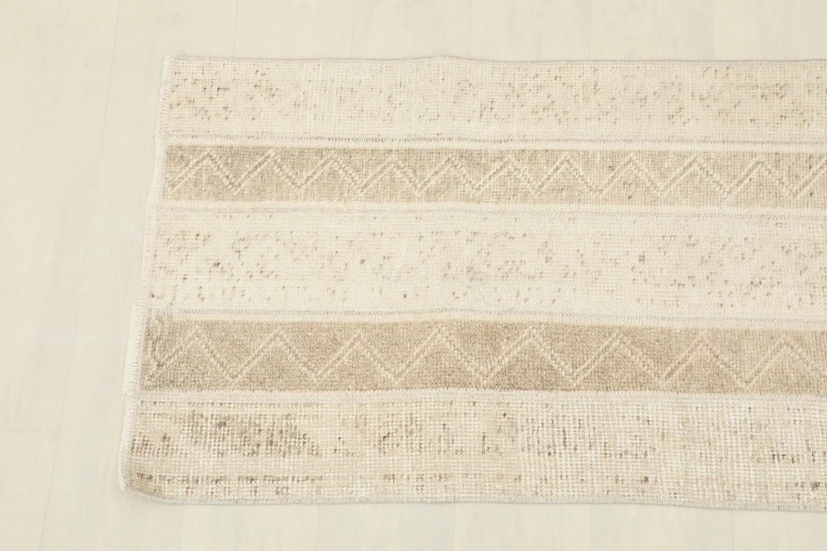 Overhead close-up of the beige and tan runner, highlighting the faded striped design.