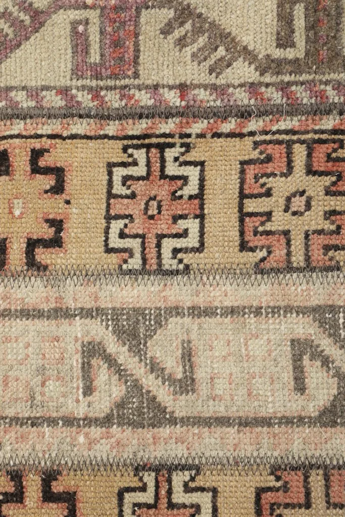 Extreme close-up of the wool pile, showing individual knots and color blend of tan, rust, and brown