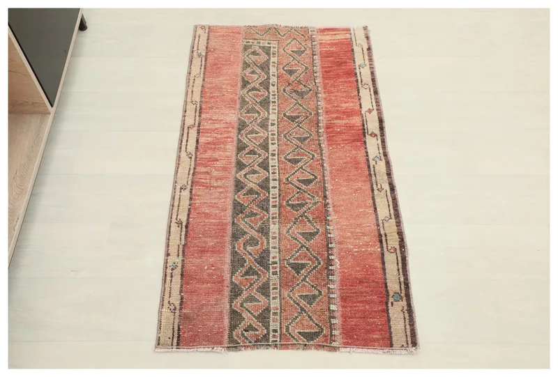 Full top view of the vintage Anatolian rug on a white background, showcasing its red, beige, and charcoal geometric pattern.