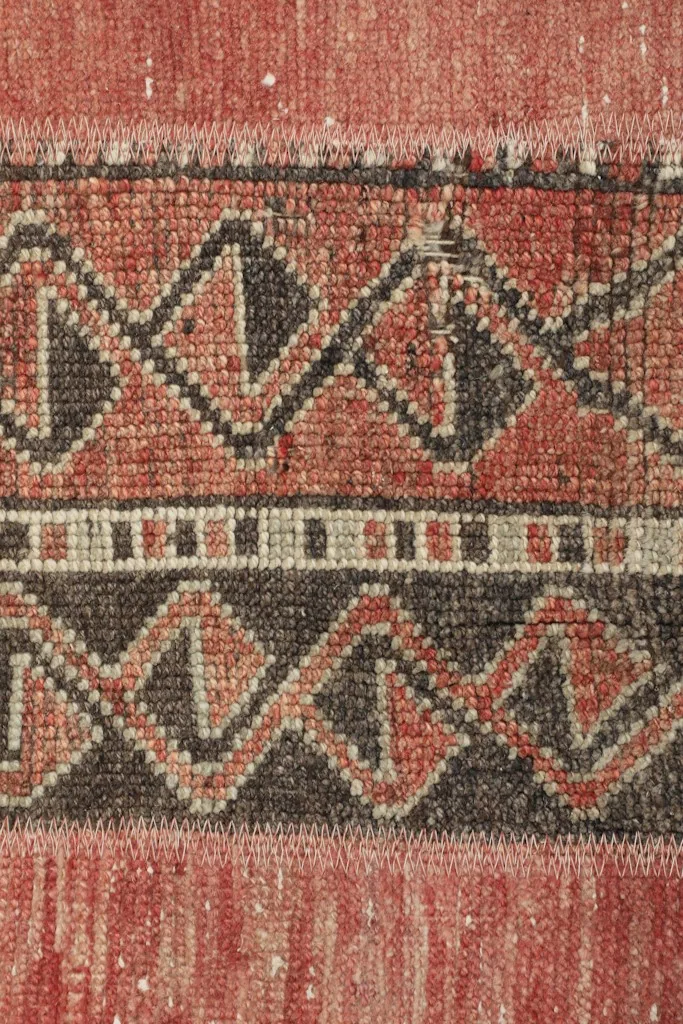Macro detail of the hand-knotted construction and the low pile, revealing individual knots and wool texture.