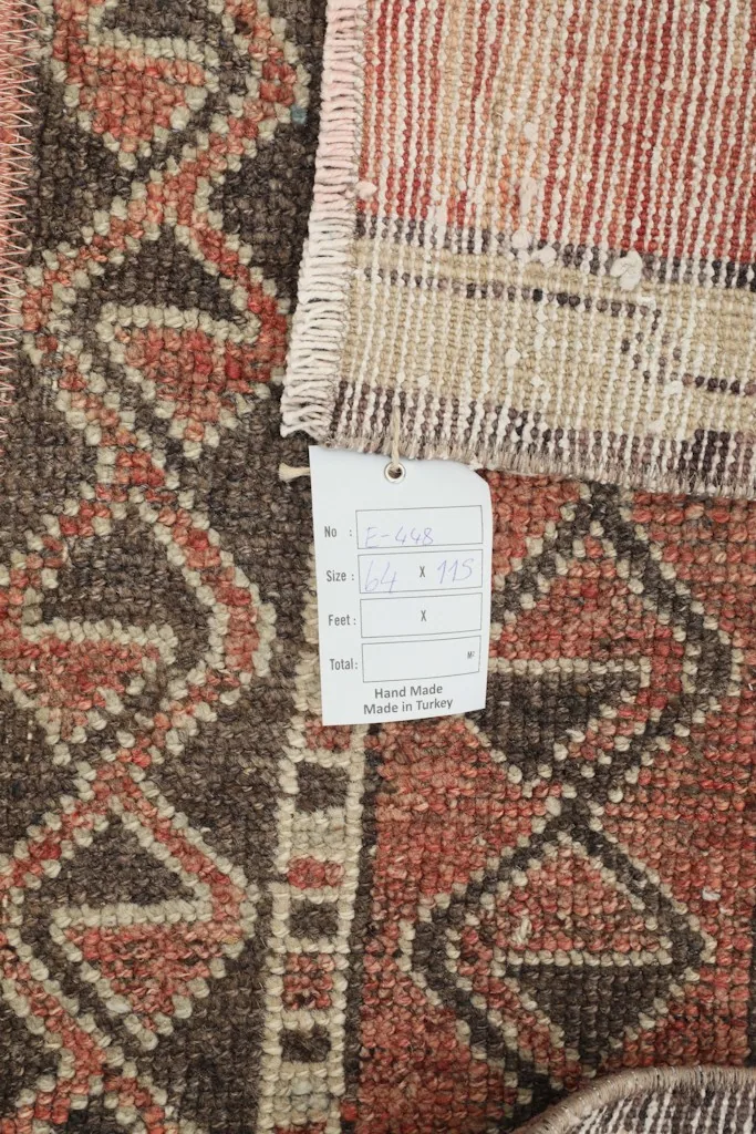Close-up of the rug's back with a product tag, showing the hand-knotted detail and the wool material.