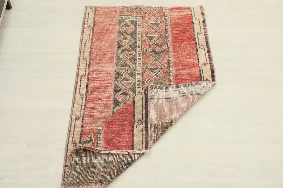 Rug partially folded, demonstrating its flexibility and the consistent pattern from top to bottom.