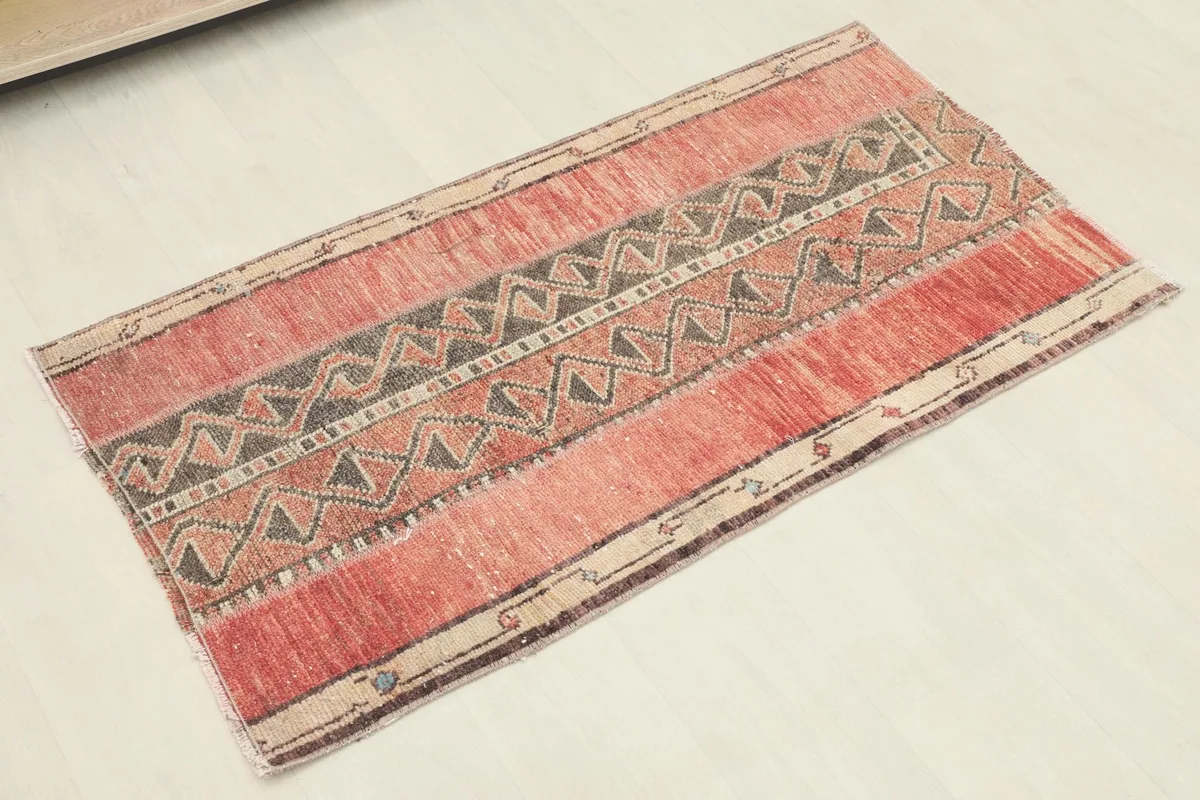 Slightly angled overhead view of the hand-knotted rug, highlighting the textured wool pile and color variations.