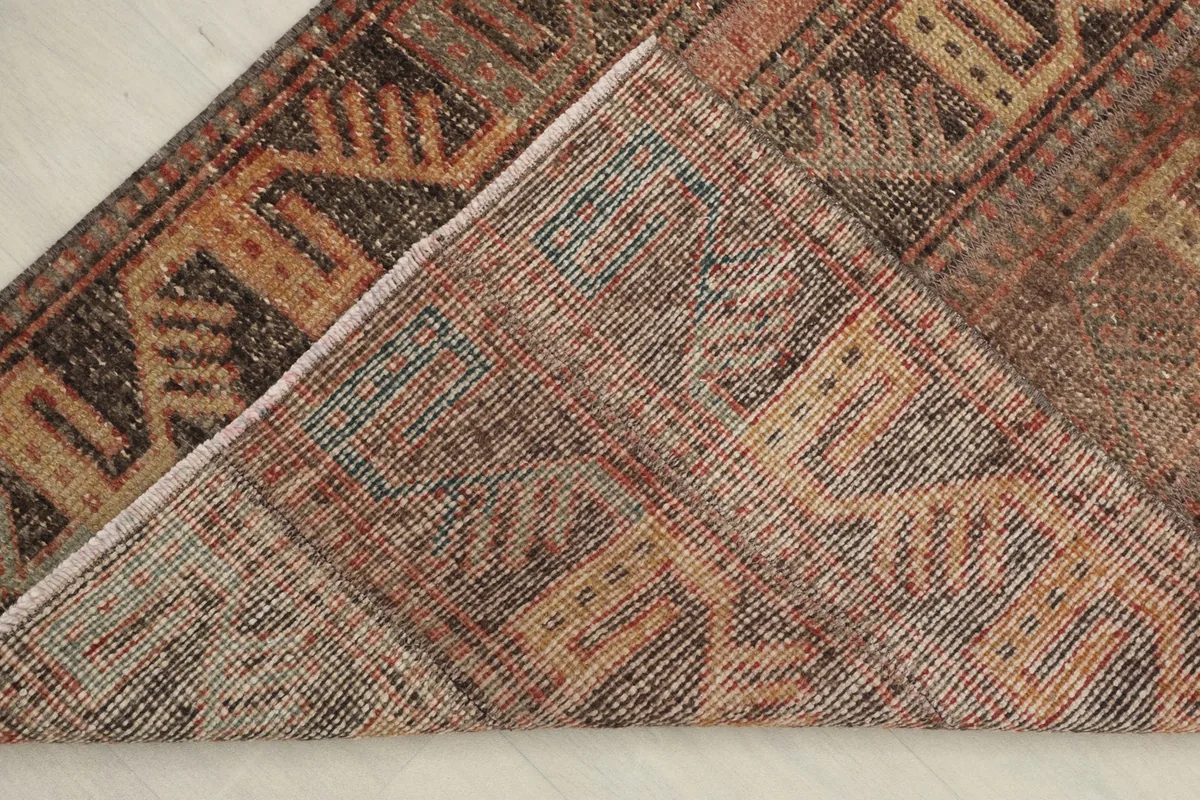 View of the back of the rug, showing the cotton foundation and knotting structure.