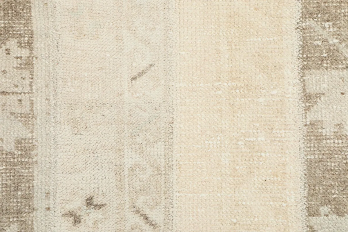 Close-up of the low wool pile and cotton foundation, revealing subtle wear