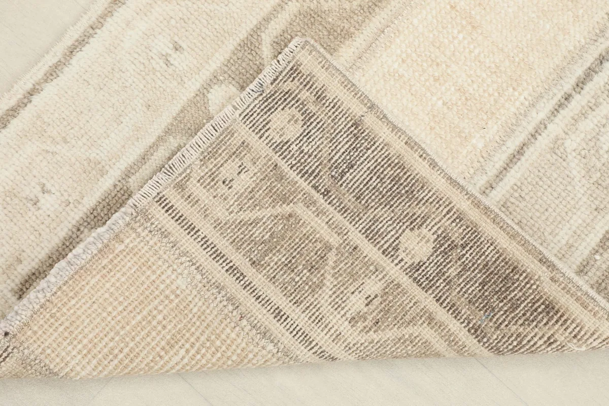 View of the back of the rug, folded to reveal the cotton foundation and hand-knotted construction.