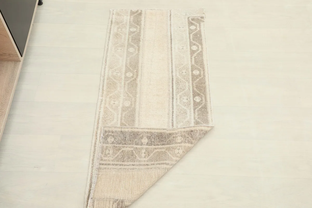 The vintage Anatolian rug partially folded, displaying its flexibility and full design.