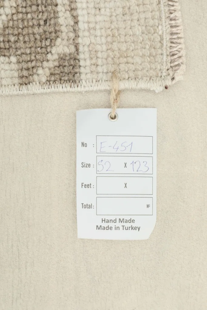 Close-up of the product tag indicating 'Hand Made Made in Turkey' and rug dimensions.