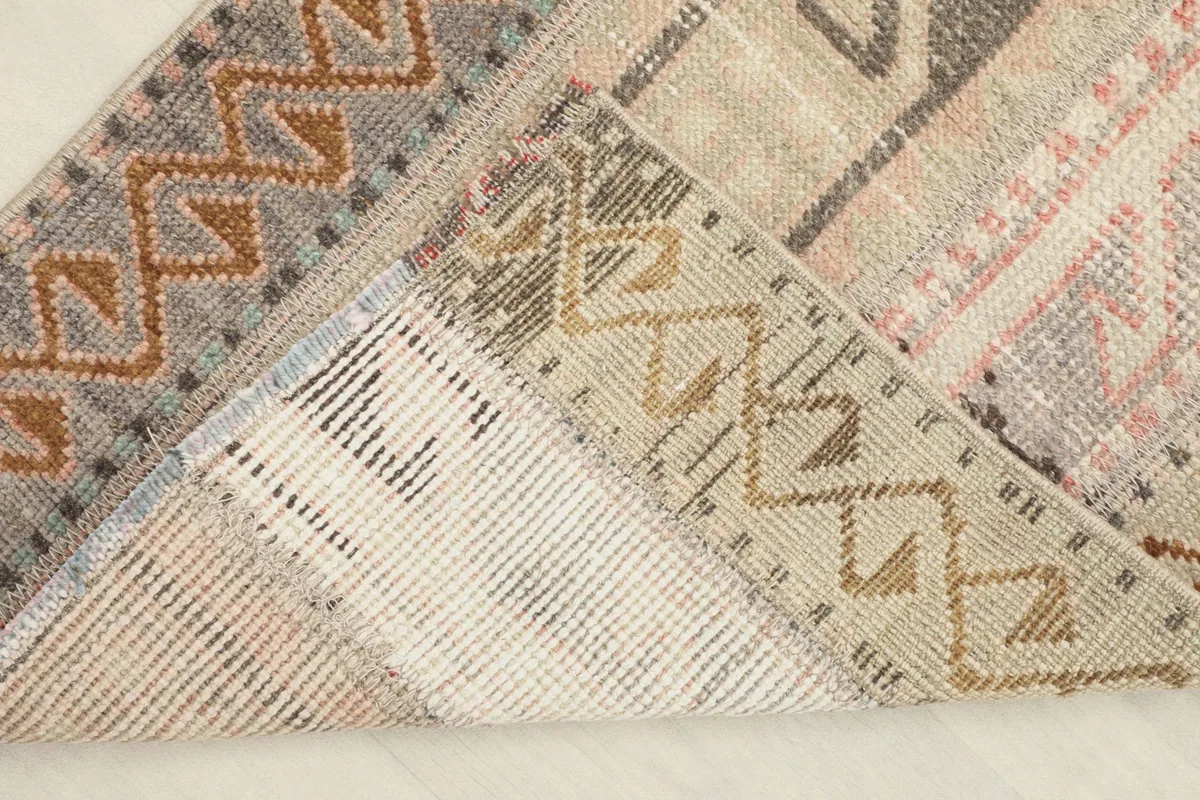 View of the back of the rug, folded to show the hand-knotted wool pile on cotton foundation.