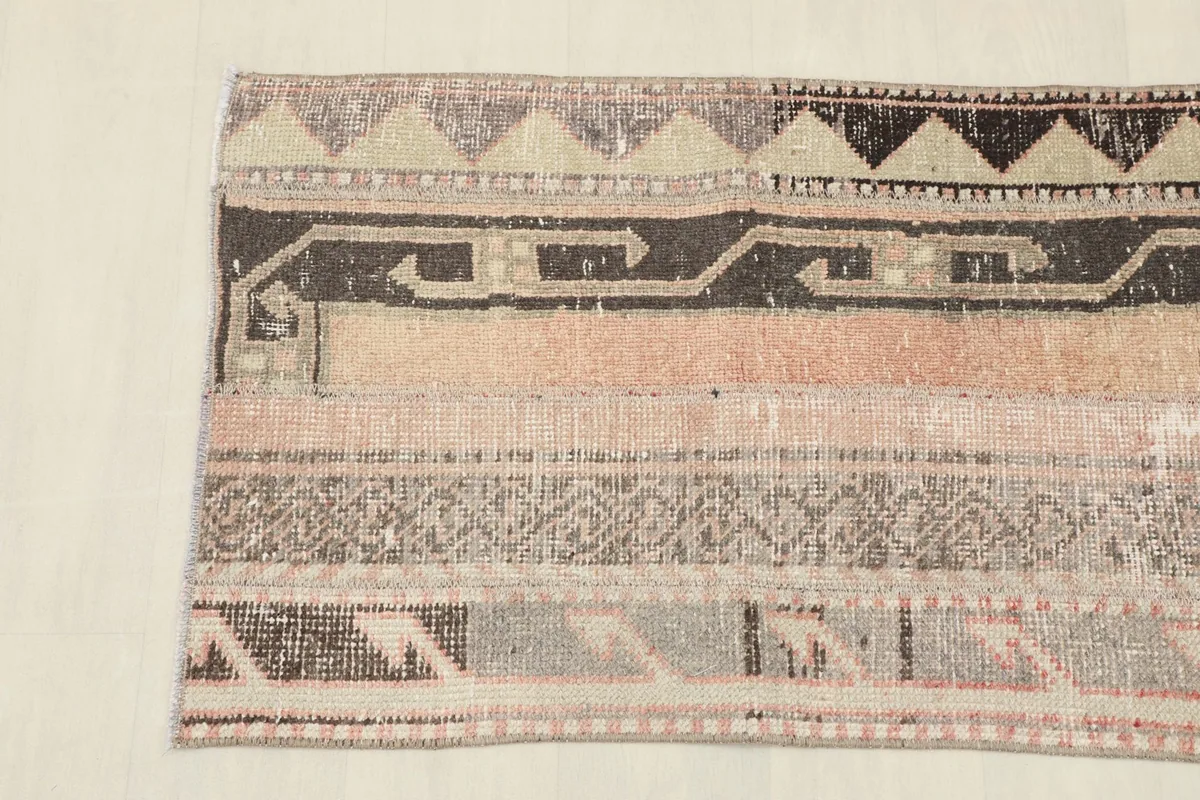 Overhead close-up showing the intricate geometric motifs and color variations in the rug's design.
