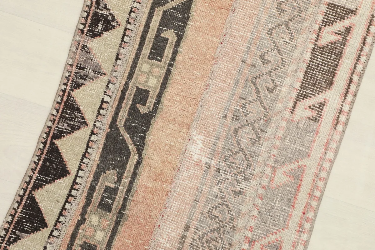 Diagonal close-up highlighting the different patterned strips and the low pile of the vintage wool runner.