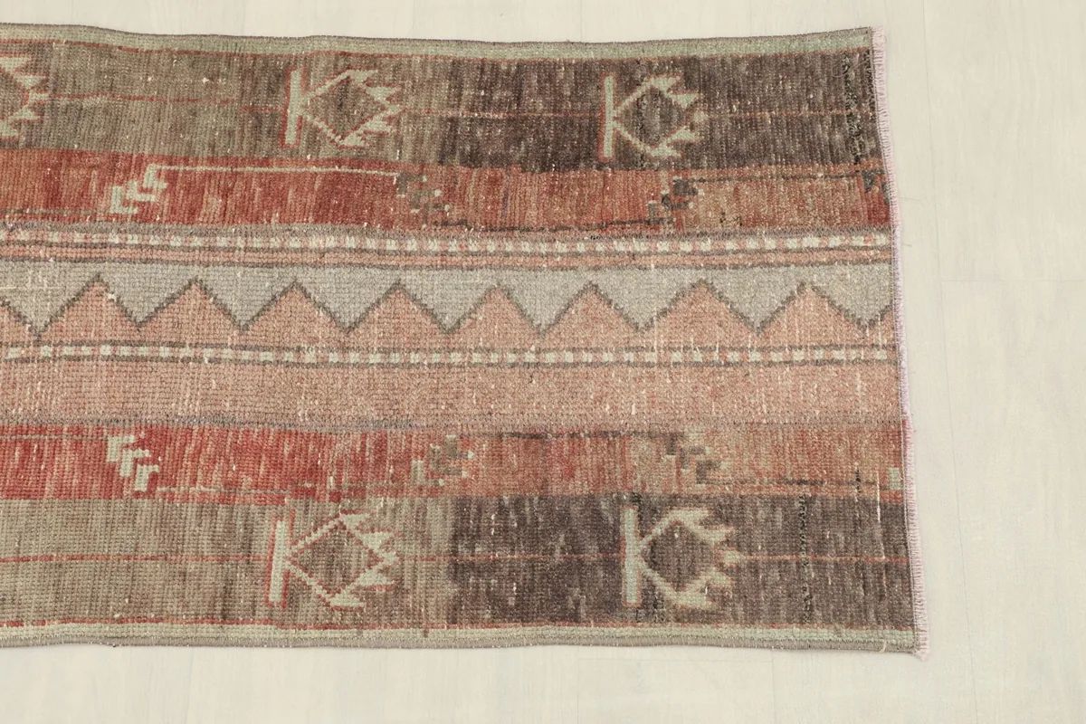 Close-up of the rug's surface, highlighting the striped design and geometric motifs.