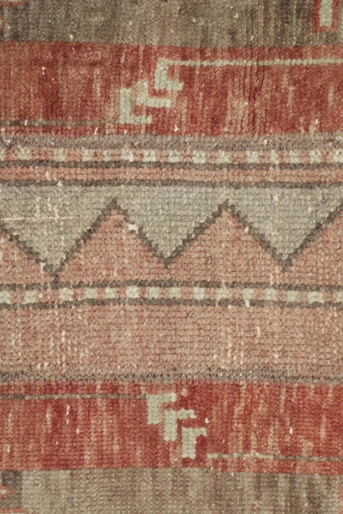 Detailed shot of the wool pile, revealing the hand-knotted texture and color blending.
