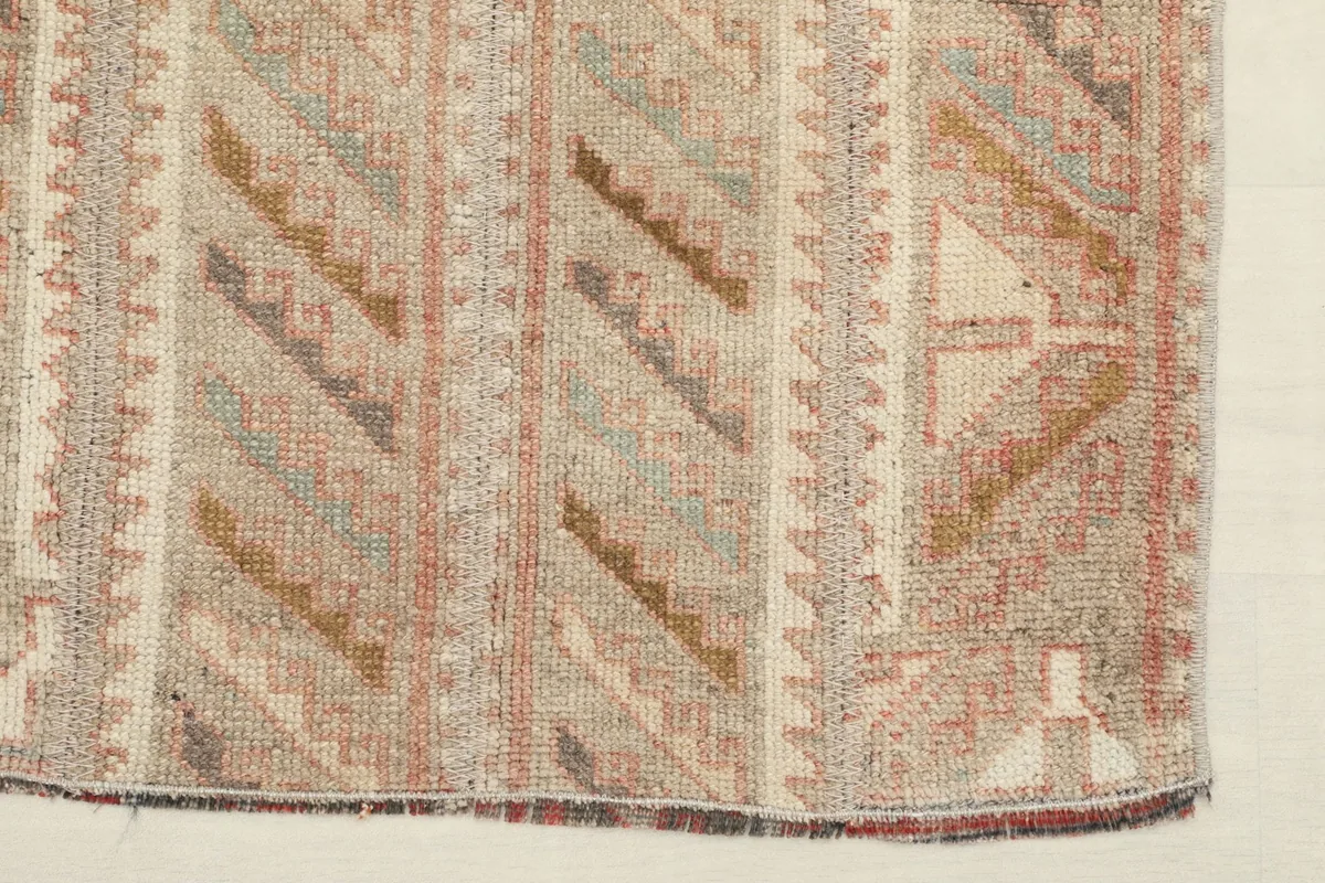 View of the rug's corner and side, displaying the finished edge and a section of the pattern.