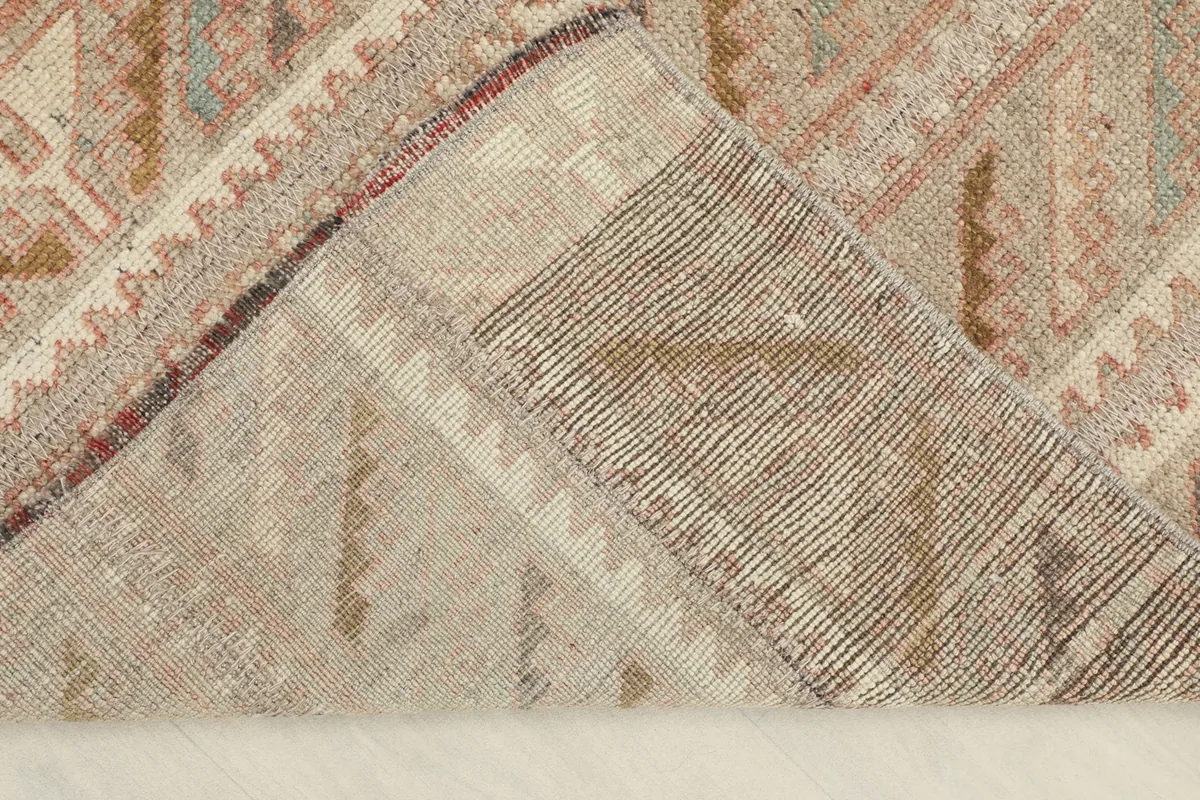 Underside view of the rug, folded to show the cotton foundation and hand-knotted construction.