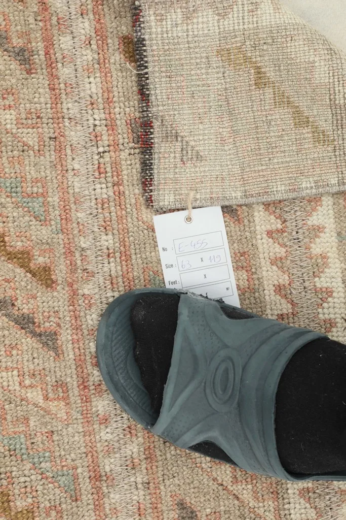 A foot next to the rug, indicating the scale and the rug's texture.