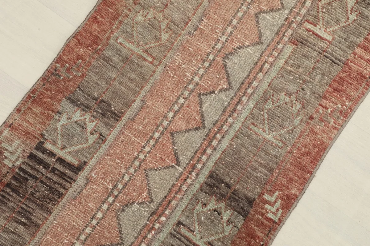 Angled close-up of the center design elements, including zigzag and diamond shapes in rose and gray.