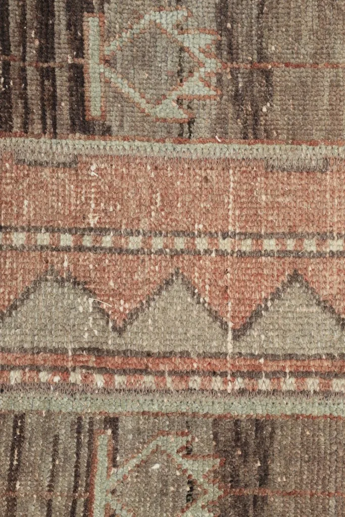 Detailed view of the central stripe with rose and gray geometric patterns and subtle color shifts.