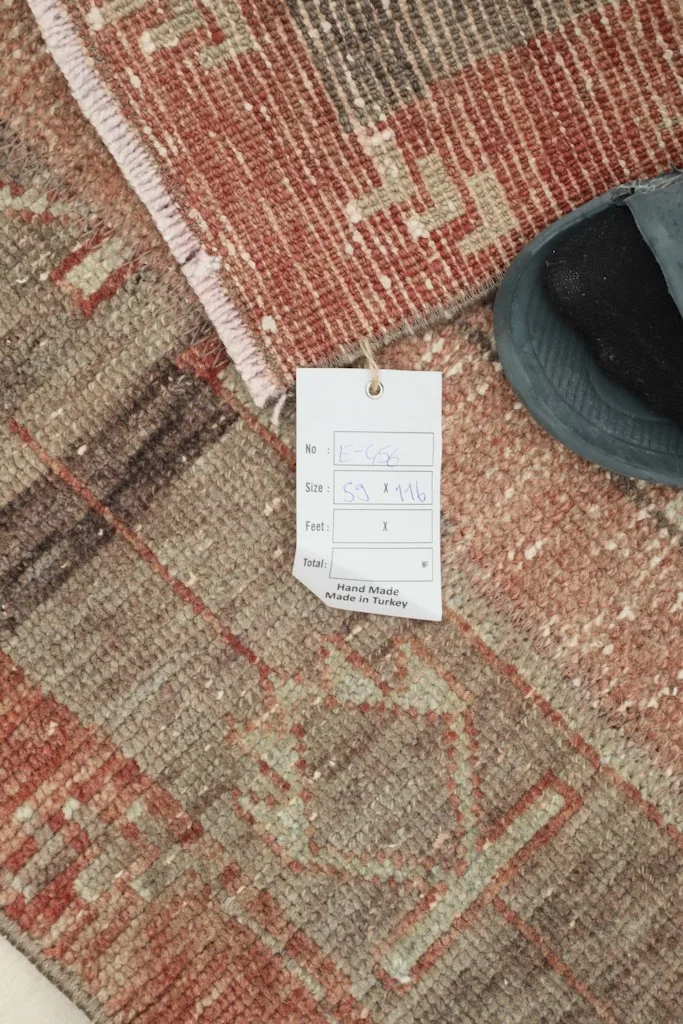 Close-up showing the rug's tag with dimensions and origin, placed on the rug surface.
