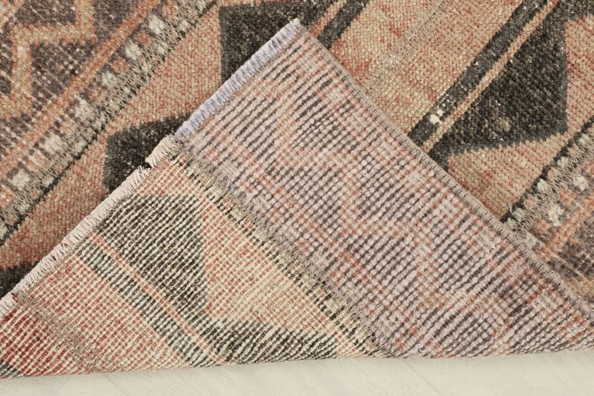View of the rug's cotton foundation and the reverse side of the hand-knotted construction.
