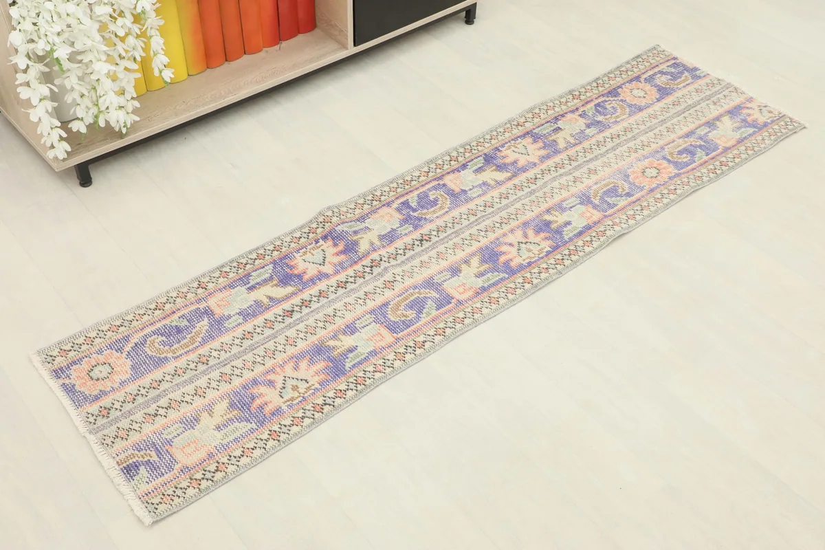 Overhead view of the purple and beige vintage runner rug, showing its full length and patterns.