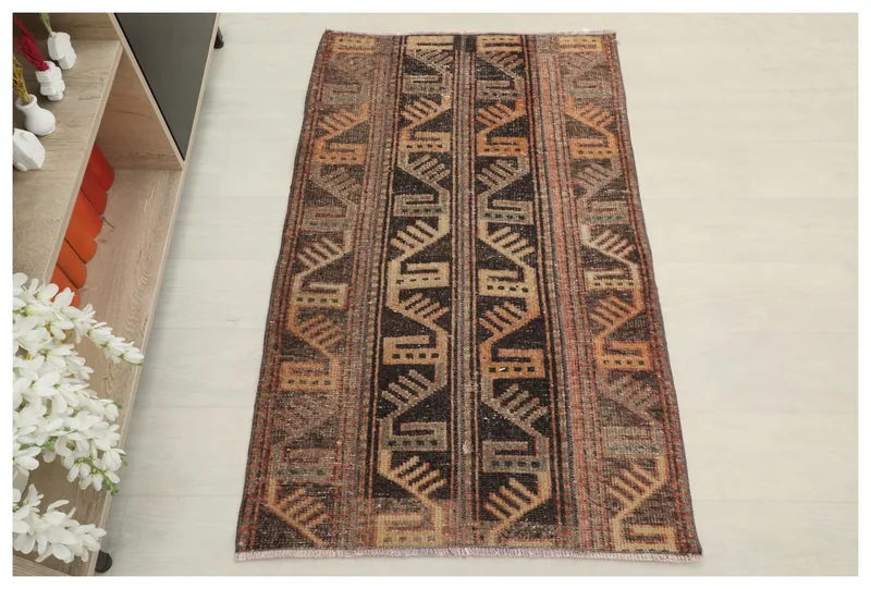 Full top view of the 2'7" x 4'2" brown geometric vintage rug on a white background