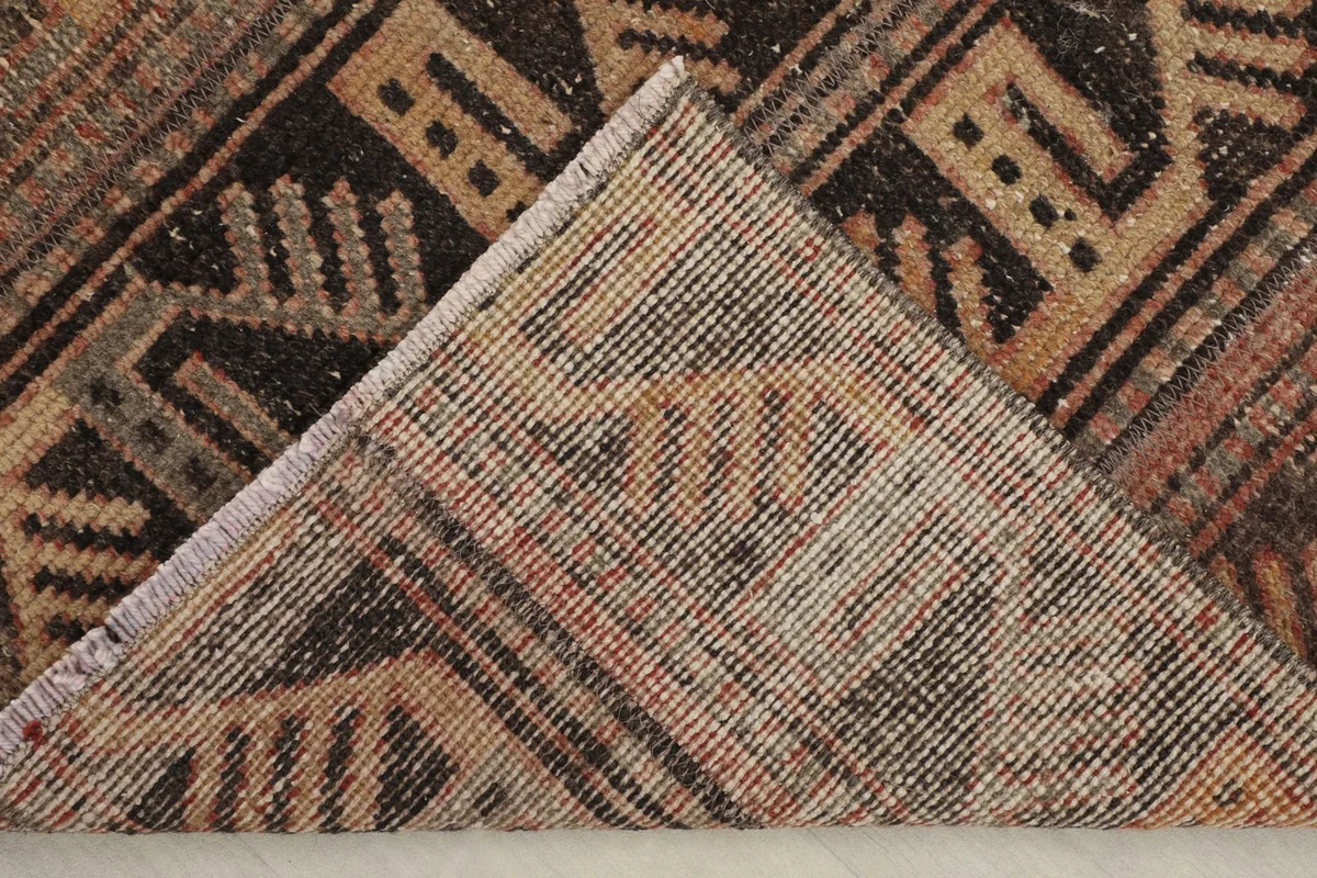 View of the rug's folded corner, revealing the cotton foundation and reverse side