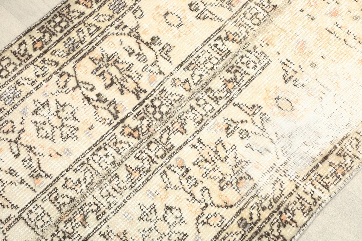 Angled view highlighting the rug's distressed texture and the intricate details of its central motifs.