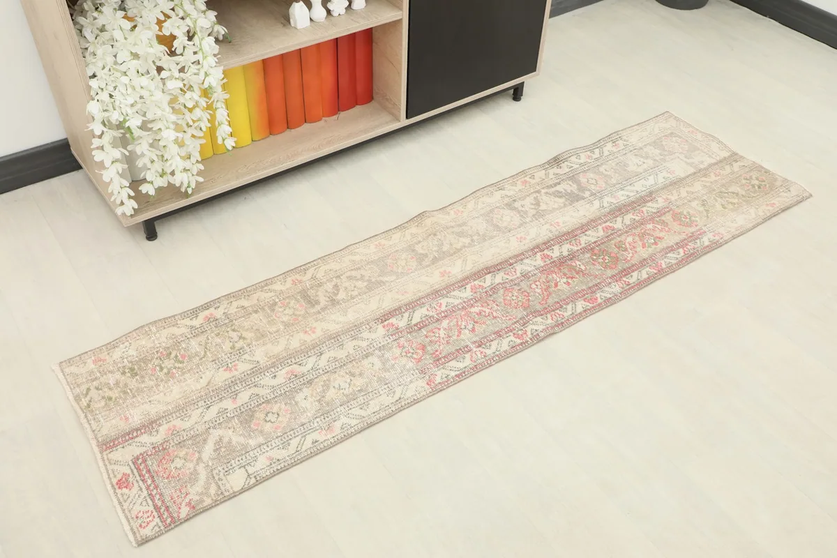 Angled top view of the tan and rose patchwork runner rug, showing its full length and unique design.