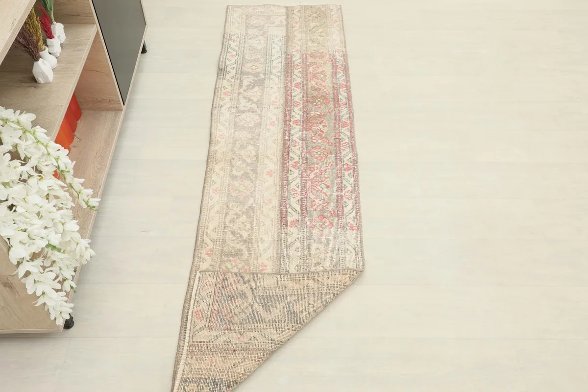 The runner rug partially folded, providing a sense of its size and drape in a room setting.