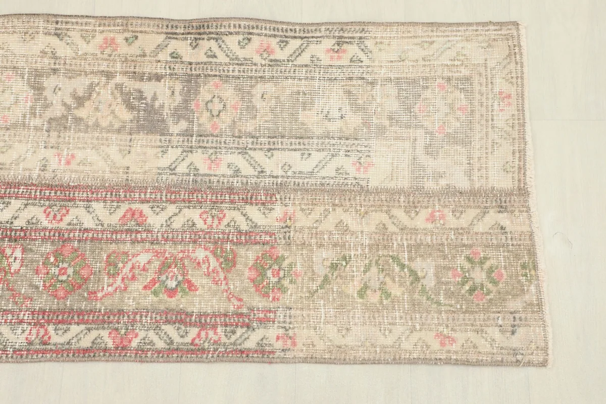 Close-up detail of the patchwork sections, revealing geometric motifs in tan, gray, rose, and olive.