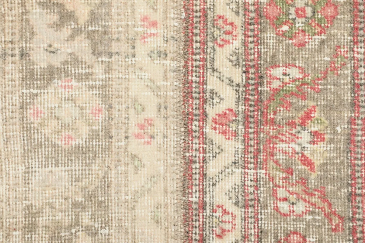 Macro view of the low wool pile and the intricate hand-knotted weave of the rug's surface.
