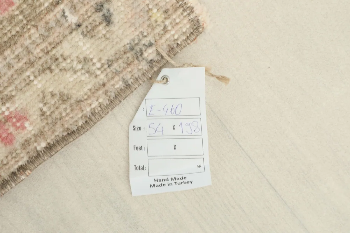 Close-up of the size tag attached to the rug, indicating its dimensions in feet and centimeters.