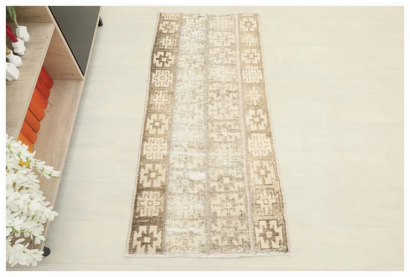 Full top view of the beige and brown geometric vintage Anatolian rug on a white floor.