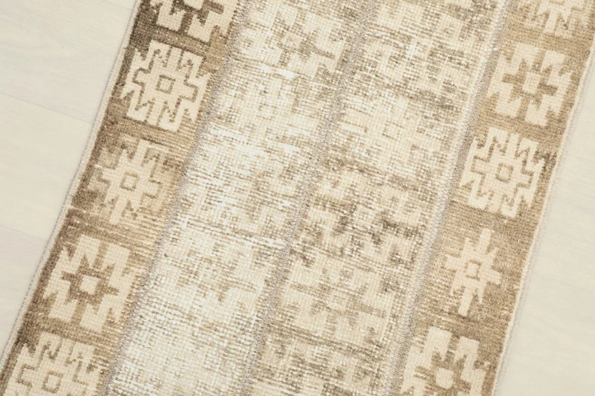 Angled close-up view of the rug's texture and the distressed low pile.