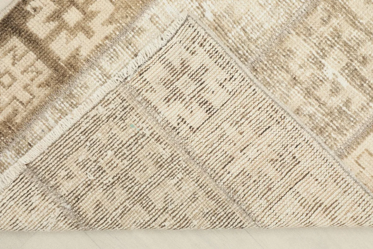 View of the back of the rug, folded to reveal the hand-knotted construction and foundation.