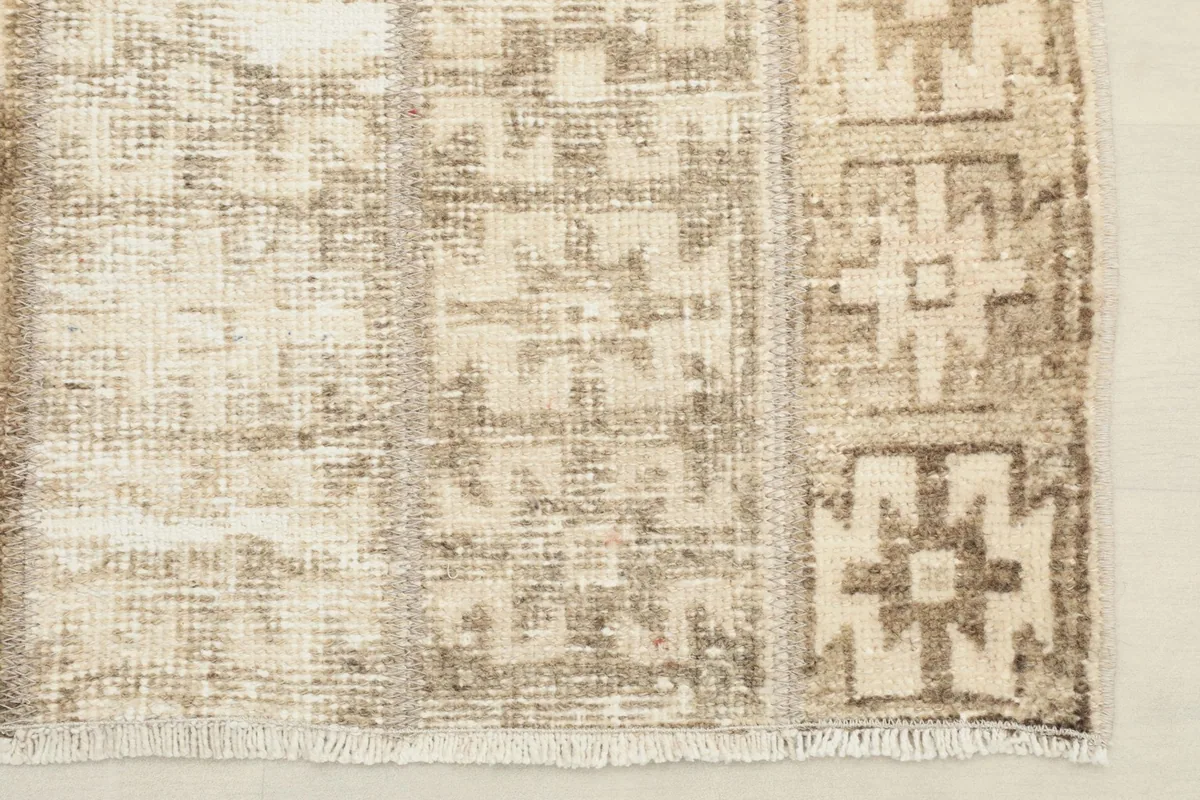 Close-up of one end of the rug, showing the short fringe and the edge binding.