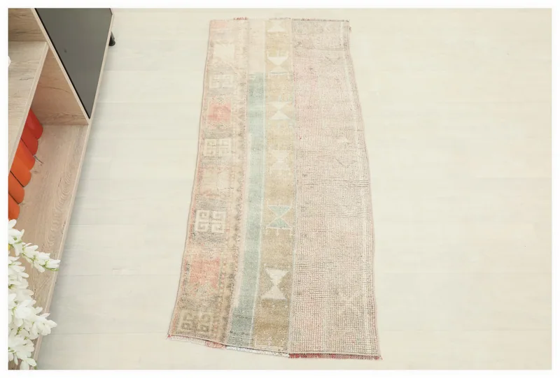 Full overhead view of the beige and rose geometric vintage Anatolian rug on a white background.