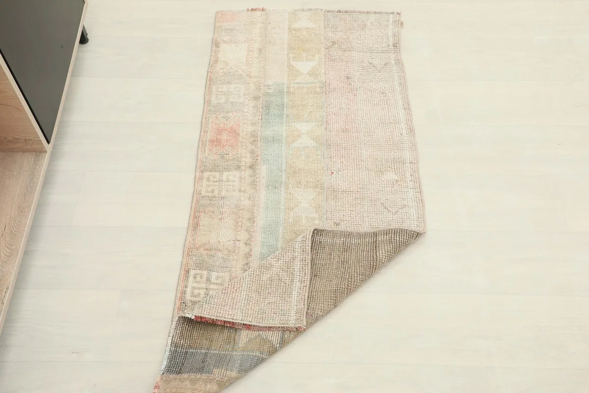 The vintage Anatolian rug folded, showing its flexibility and the reverse side of the hand-knotted construction.