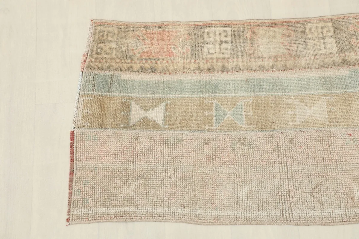 Overhead perspective highlighting the varied geometric designs and color transitions across the vintage wool rug.