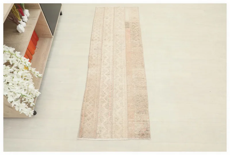 Full overhead view of the beige and tan striped patchwork runner rug on a white background.
