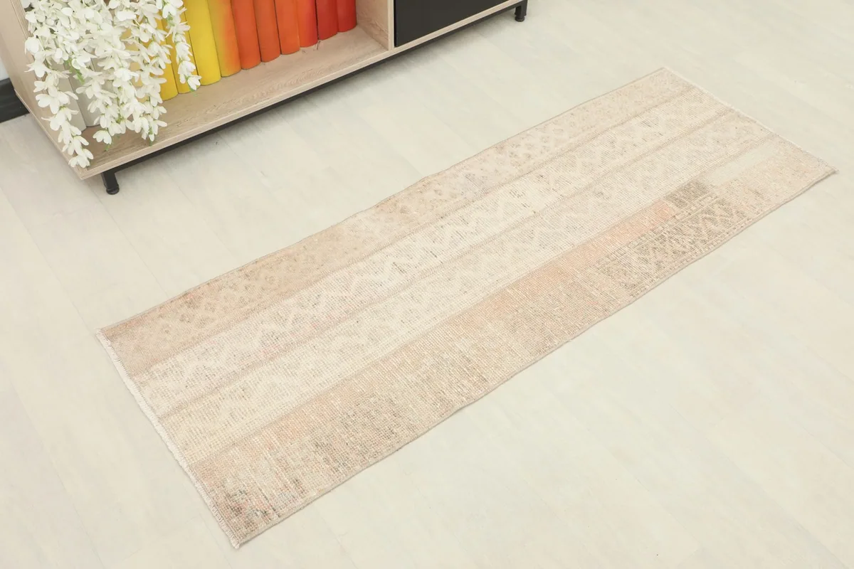 Angled view of the vintage runner rug, showing its full length and patchwork design.