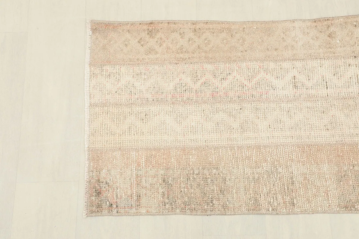 Detailed view of the rug's upper section, showing the subtle geometric patterns within the striped design.