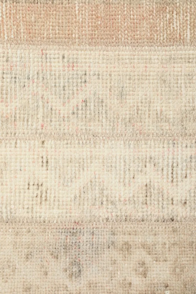 Tight close-up showing the low wool pile and the hand-knotted texture of the vintage rug.