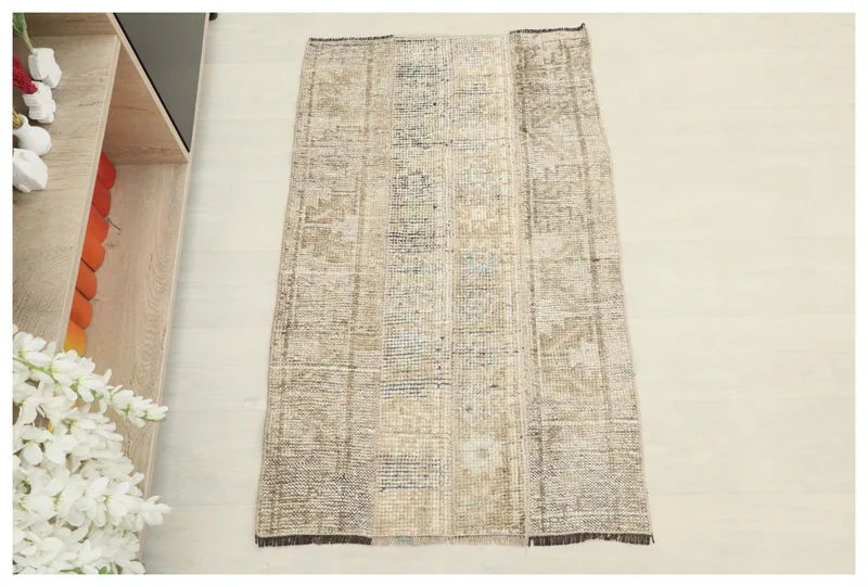 Full top view of the 2'3" x 3'8" beige and brown patchwork vintage Anatolian rug on a white background.