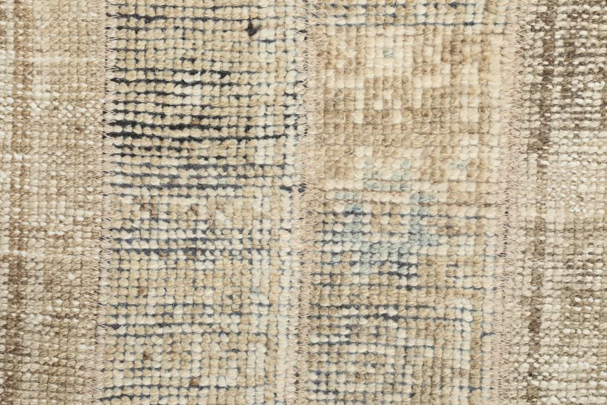 Extreme close-up of the low wool pile, illustrating the hand-knotted texture and color variations.