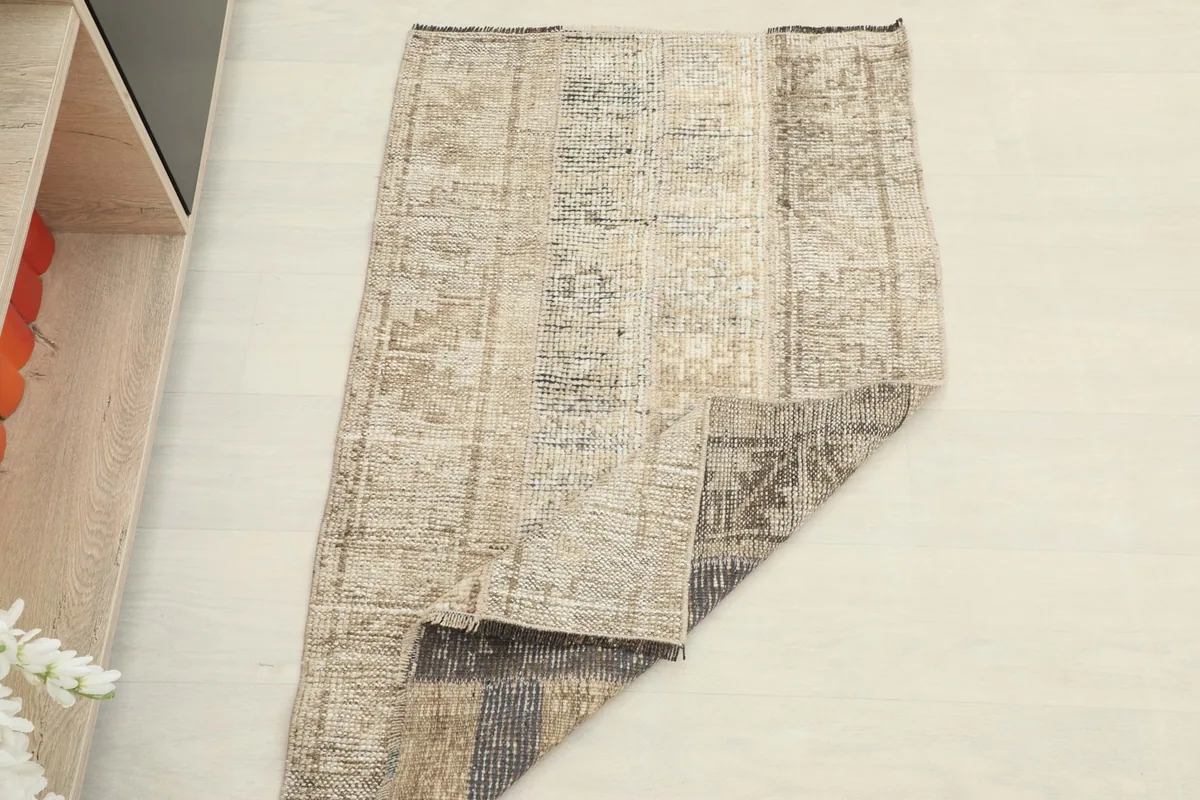 The rug partially folded, demonstrating its flexibility and the different tones on the back.